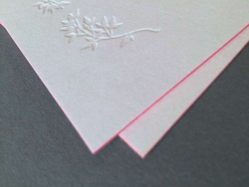 Hochzeitskarte mit Blindprägung und Farbschnitt. Hochzeitskarten aus der Druckerei Werkstatt Dietz München Detailansicht einer Blindprägung tief mit Letterpress ohne Farbe mit neonrotem Farbschnitt
